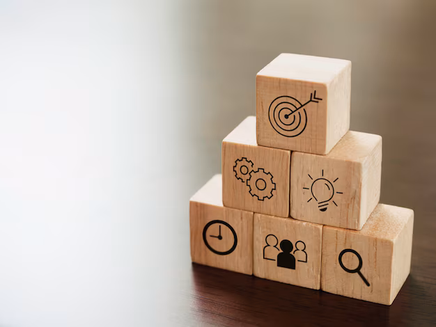houten blokken in een piramidevorm op een bureau, met pictogrammen die doelen en strategieën symboliseren, als metafoor voor succes en groei.